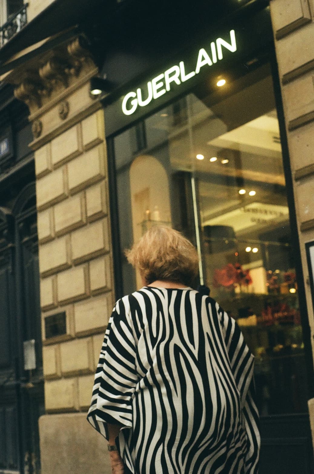 Barthelemy de Mazenod | People of Paris | An old woman wearing a zebra dress in front of a Gerlain store